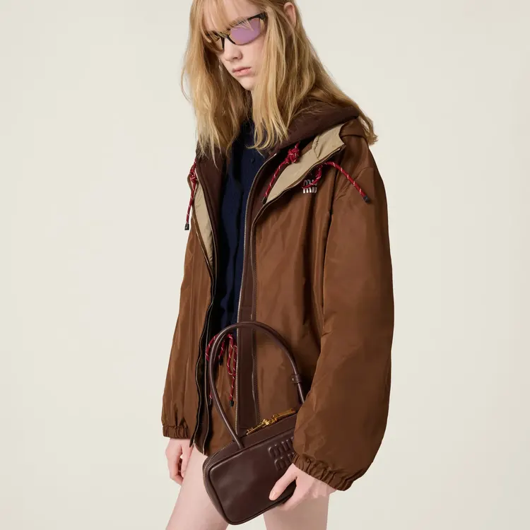 Model carrying a burgundy Miu Miu Beau Bag at her hip