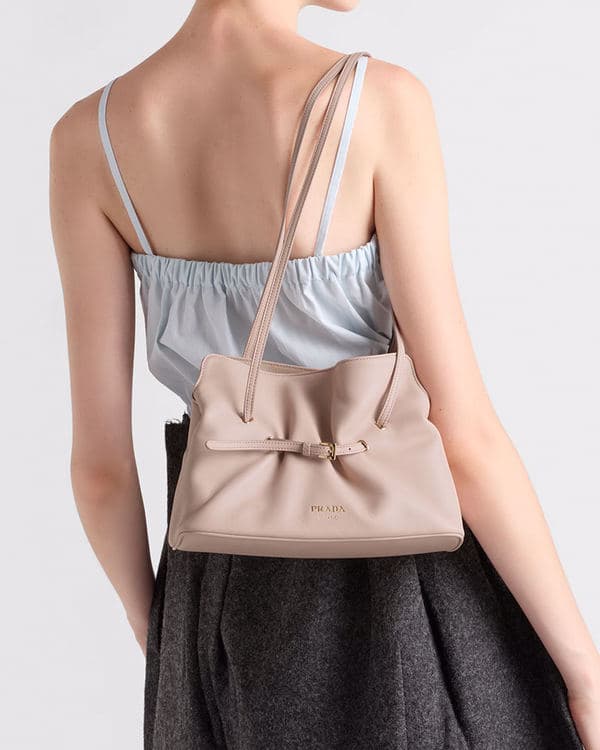 Rear view of a model carrying a pale pink Prada Dada on her shoulder