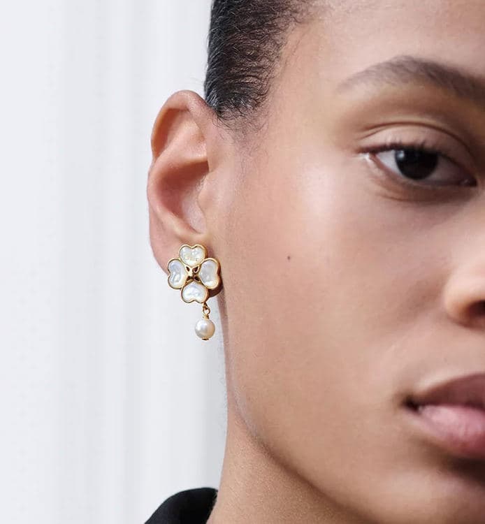 Model wearing a Dior clover earring with a pearl drop