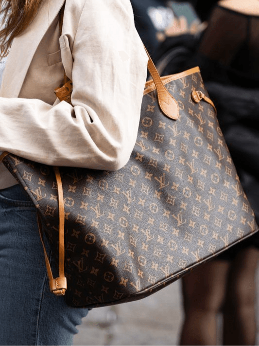 Louis Vuitton Neverfull in Monogram pattern carried under the arm