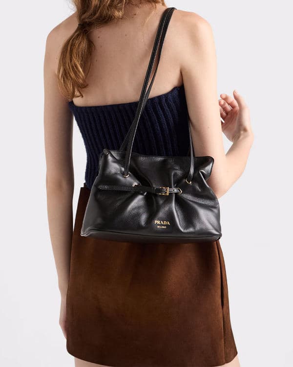 Black Prada Dada carried over the shoulder with a brown dress