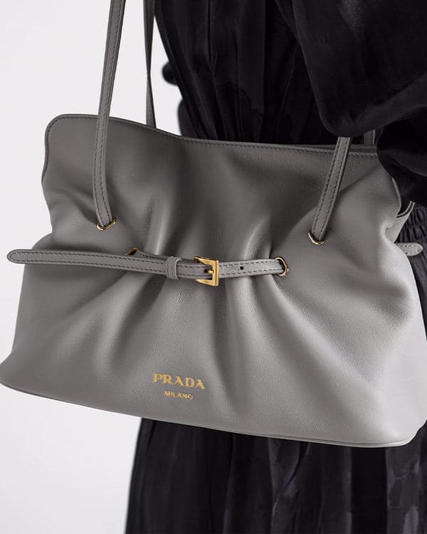 Close-up of a large grey Prada Dada with belt detail and gold logo