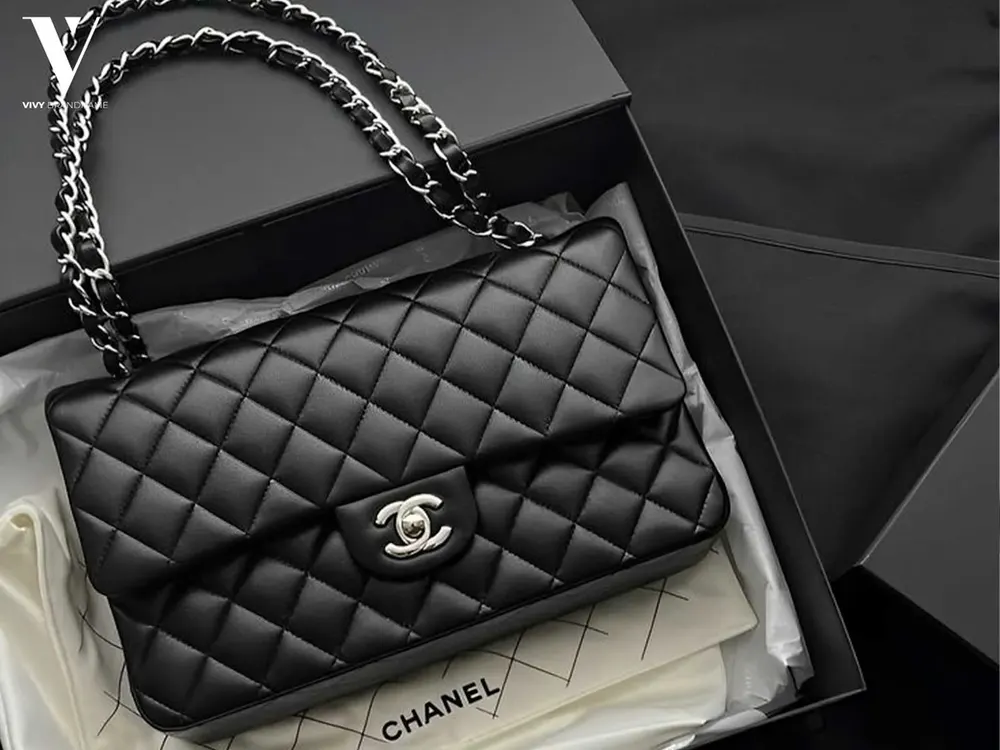 Black quilted Chanel flap bag resting in an open presentation box